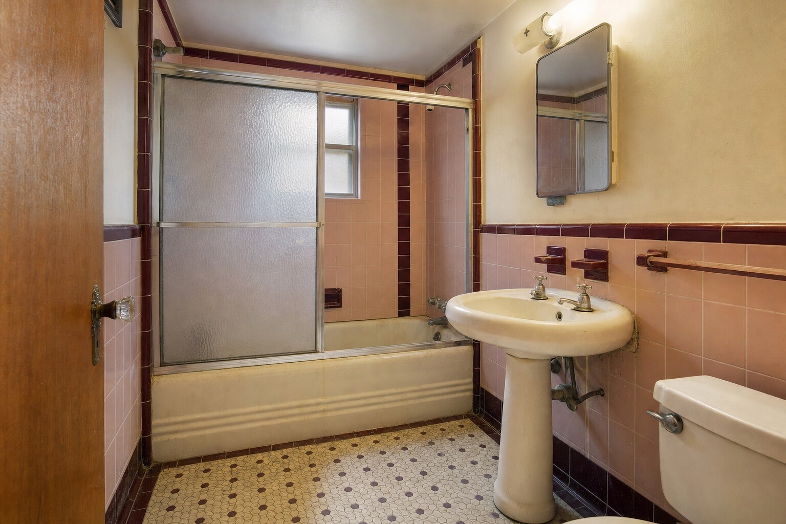 Dated 1950s pink-tile hall bathroom before remodeling