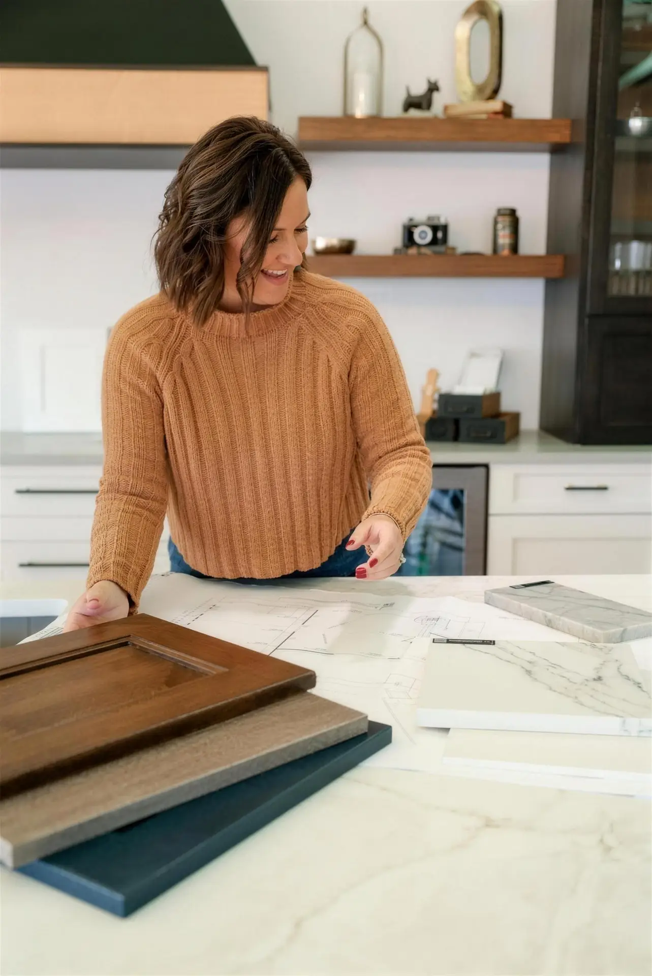 Kendra Wallace of 3 Day Kitchen and Bath reviewing cabinet door and quartz countertop samples on a marble island