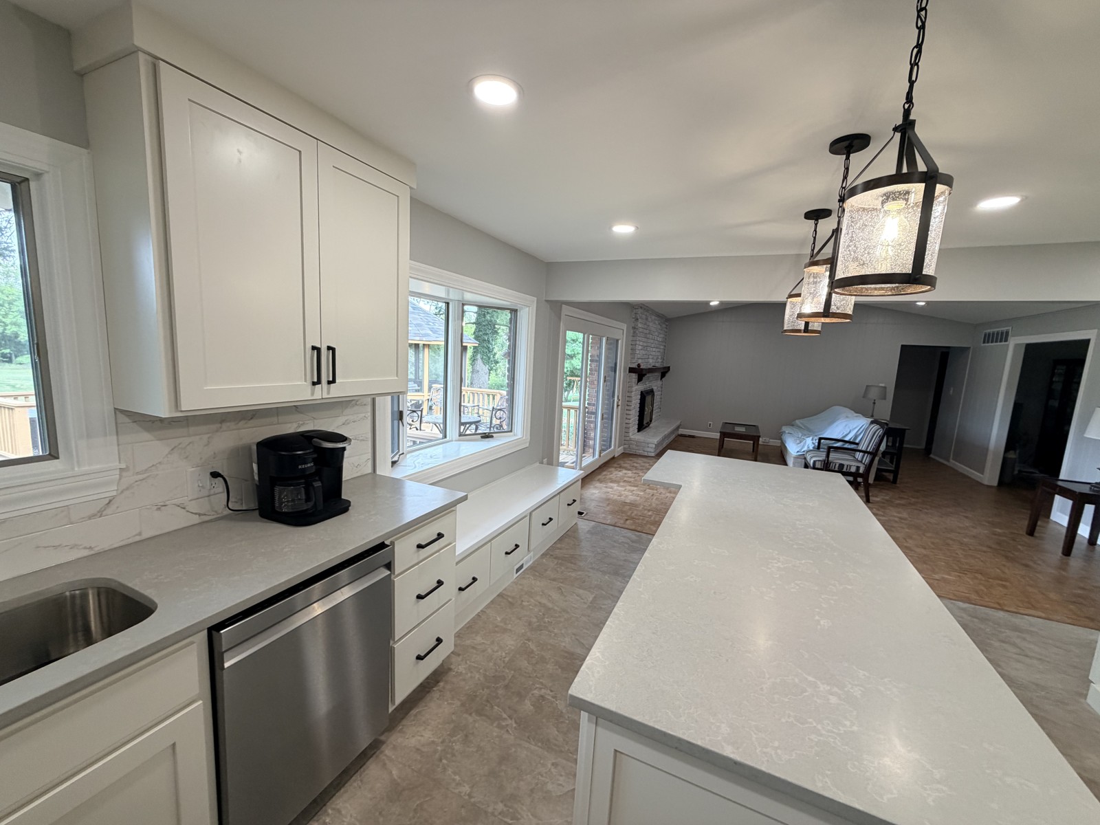 White cabinetry, central island, pendant lighting and window seat in a Chesterfield, Missouri kitchen